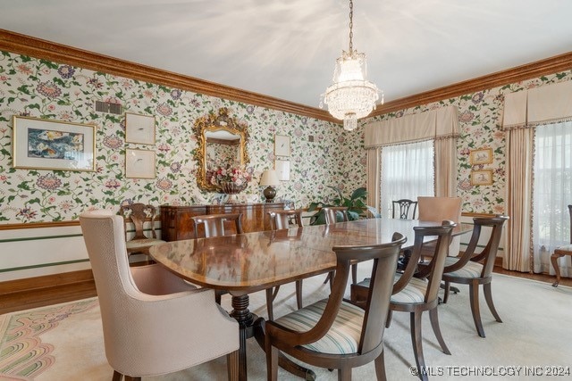 dining area with light wood-type flooring, a notable chandelier, and ornamental molding