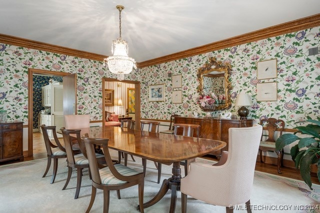 carpeted dining room featuring a chandelier and crown molding