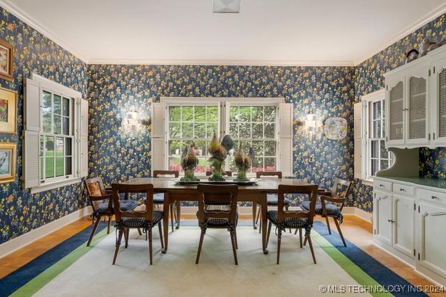 2840 S Victor Ave, Tulsa, OK 74114 - dining space with wallpapered walls, light wood-style flooring, crown molding, and healthy amount of natural light