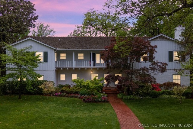 view of front of property with a lawn and a balcony