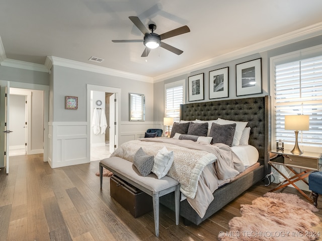 bedroom with ornamental molding, ensuite bath, wood-type flooring, and ceiling fan