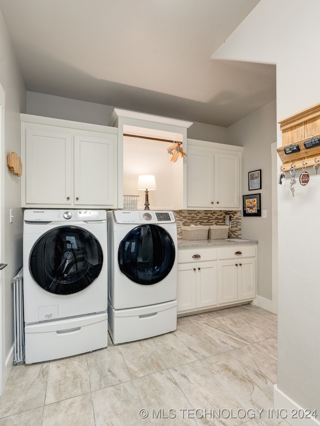 washroom with washer and clothes dryer and cabinets