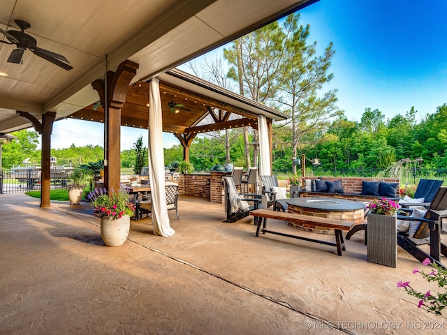 view of patio featuring an outdoor living space with a fire pit and ceiling fan