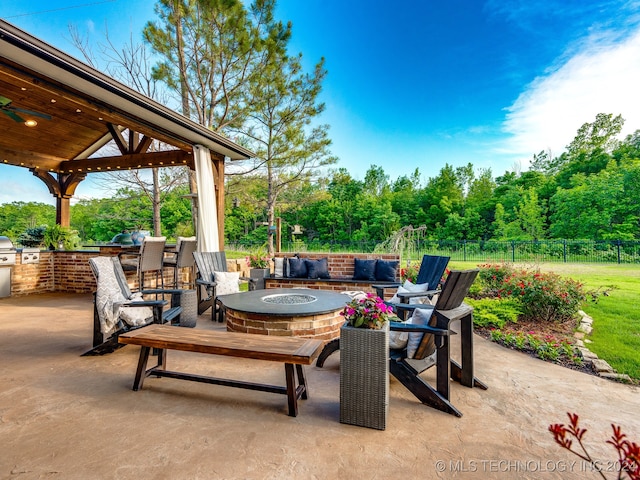 view of patio / terrace featuring a gazebo, a fire pit, and exterior kitchen