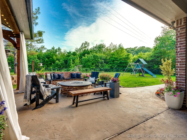 view of patio with an outdoor fire pit and a playground