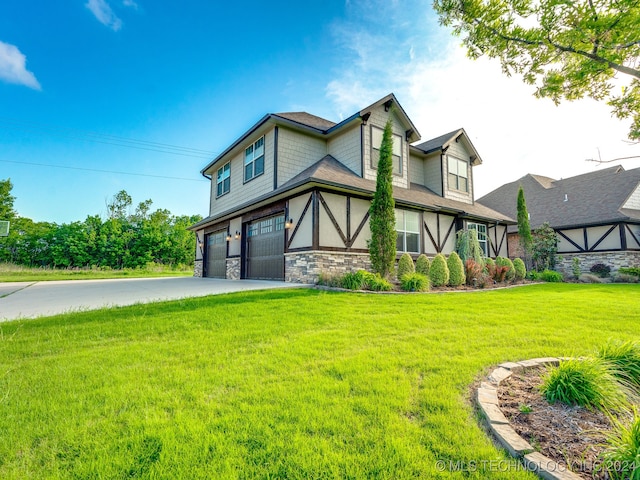 tudor house featuring a front yard and a garage