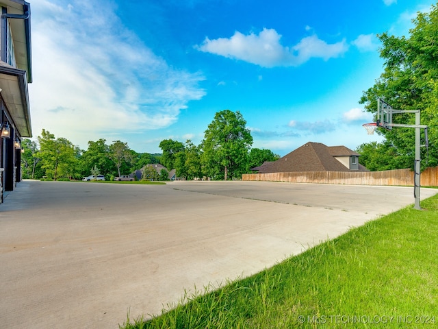 view of basketball court with a yard