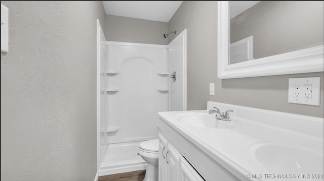 bathroom featuring walk in shower, vanity, toilet, and hardwood / wood-style flooring