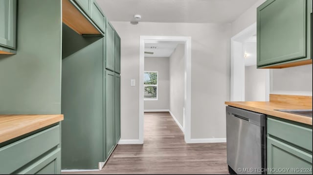 kitchen with butcher block counters, green cabinets, light wood-type flooring, and dishwasher