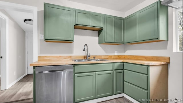 kitchen featuring dishwasher, light hardwood / wood-style floors, sink, and green cabinetry