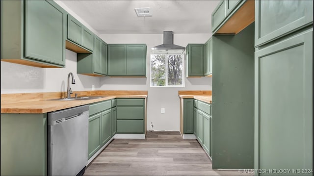 kitchen with wooden counters, green cabinets, sink, stainless steel dishwasher, and light wood-type flooring