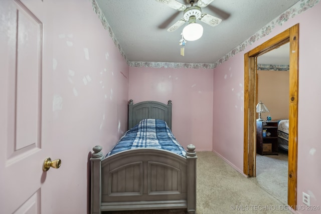 carpeted bedroom with a textured ceiling and ceiling fan