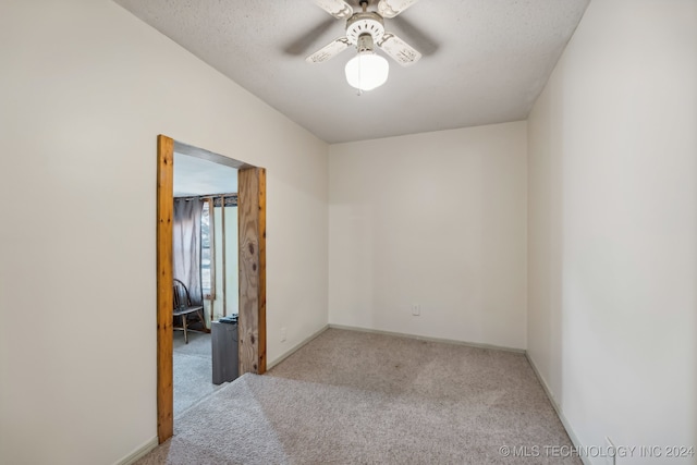 unfurnished room featuring ceiling fan, a textured ceiling, and light colored carpet