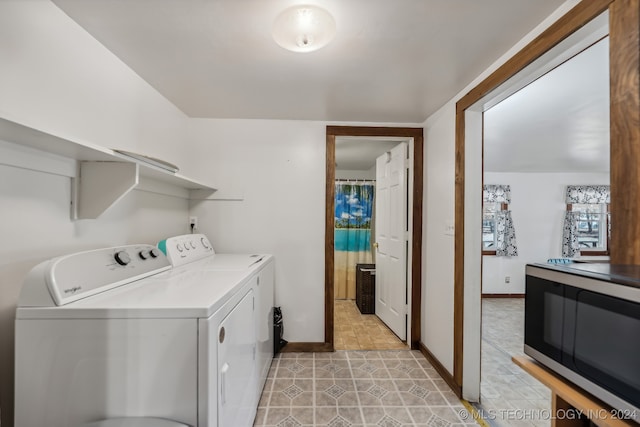 washroom with washing machine and dryer and light tile patterned floors