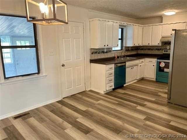 kitchen featuring appliances with stainless steel finishes, white cabinetry, tasteful backsplash, and a textured ceiling