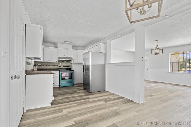 7740 Swayback, Sulphur, OK 73086 - kitchen featuring appliances with stainless steel finishes, dark countertops, a chandelier, under cabinet range hood, and light wood finished floors