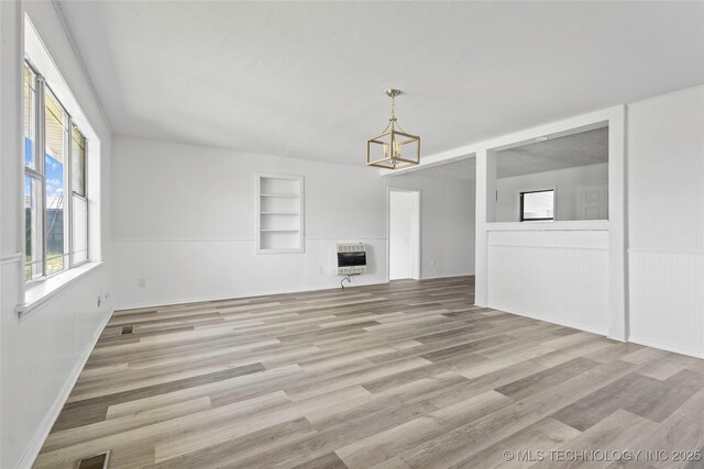 7740 Swayback, Sulphur, OK 73086 - unfurnished living room with built in shelves, a chandelier, light wood finished floors, and heating unit