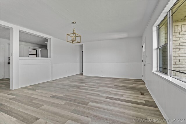 7740 Swayback, Sulphur, OK 73086 - empty room with a chandelier and light wood-style flooring