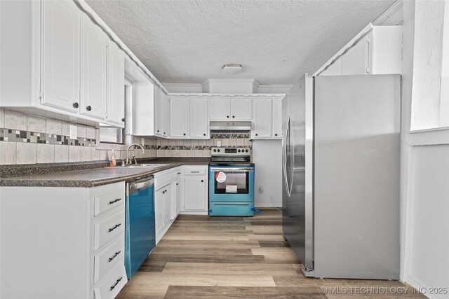 7740 Swayback, Sulphur, OK 73086 - kitchen featuring stainless steel appliances, dark countertops, under cabinet range hood, white cabinets, and tasteful backsplash