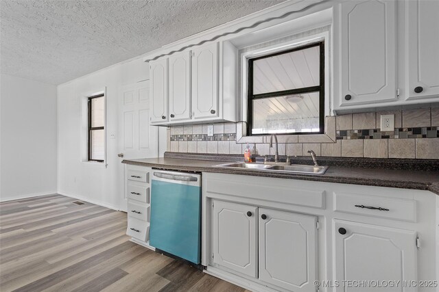 7740 Swayback, Sulphur, OK 73086 - kitchen featuring dishwasher, dark countertops, a textured ceiling, wood finished floors, and tasteful backsplash