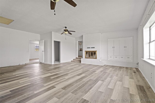 7740 Swayback, Sulphur, OK 73086 - unfurnished living room featuring ceiling fan, light wood-type flooring, and a fireplace