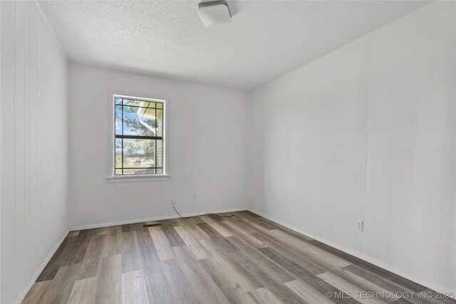 7740 Swayback, Sulphur, OK 73086 - empty room with wood finished floors and a textured ceiling
