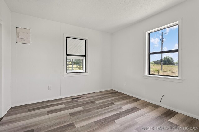 7740 Swayback, Sulphur, OK 73086 - empty room with plenty of natural light and wood finished floors