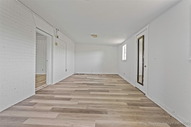 7740 Swayback, Sulphur, OK 73086 - empty room with light wood finished floors and brick wall