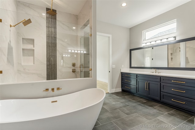 bathroom with vanity and shower with separate bathtub