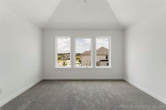 empty room with carpet and vaulted ceiling