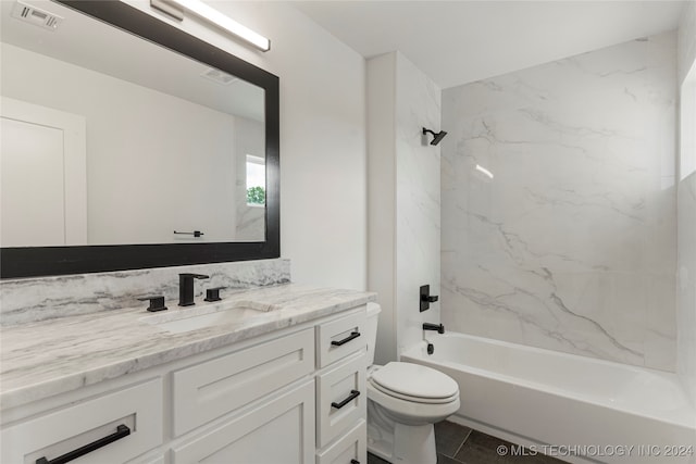 full bathroom with tiled shower / bath, vanity, and toilet