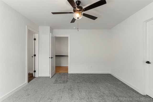 unfurnished bedroom featuring ceiling fan and dark carpet