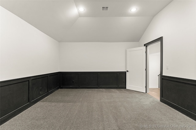 unfurnished room featuring light carpet and lofted ceiling