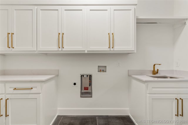 washroom featuring hookup for an electric dryer, sink, dark tile patterned floors, washer hookup, and cabinets