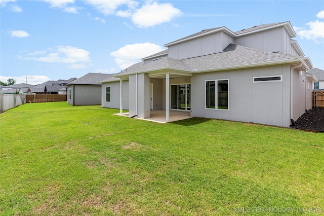 back of property with a patio area and a lawn