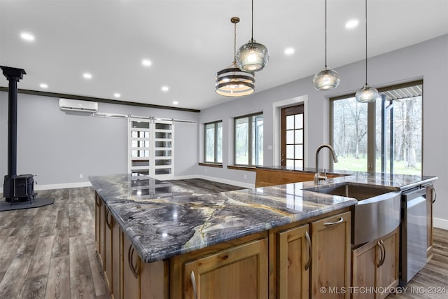 kitchen with decorative light fixtures, a wood stove, dishwasher, dark wood-type flooring, and a wall unit AC