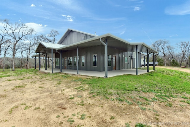 view of side of property featuring a patio and a yard