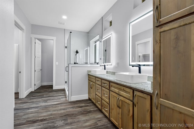 bathroom featuring vanity, hardwood / wood-style flooring, and a shower with door