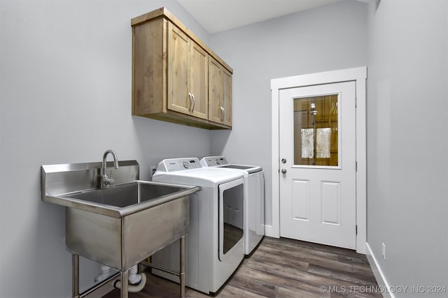 laundry room with cabinets, dark hardwood / wood-style flooring, sink, and washer and clothes dryer