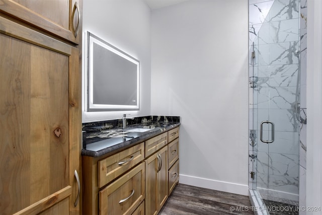 bathroom with walk in shower, vanity, and hardwood / wood-style floors