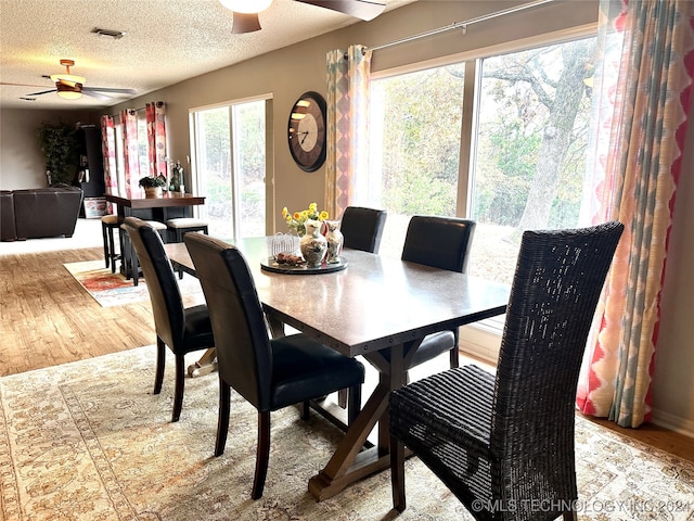 dining room featuring a textured ceiling, hardwood / wood-style flooring, and ceiling fan