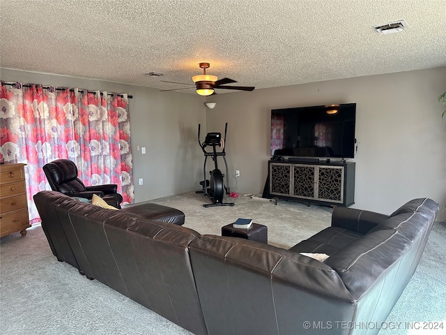 living room featuring a textured ceiling, carpet flooring, and ceiling fan