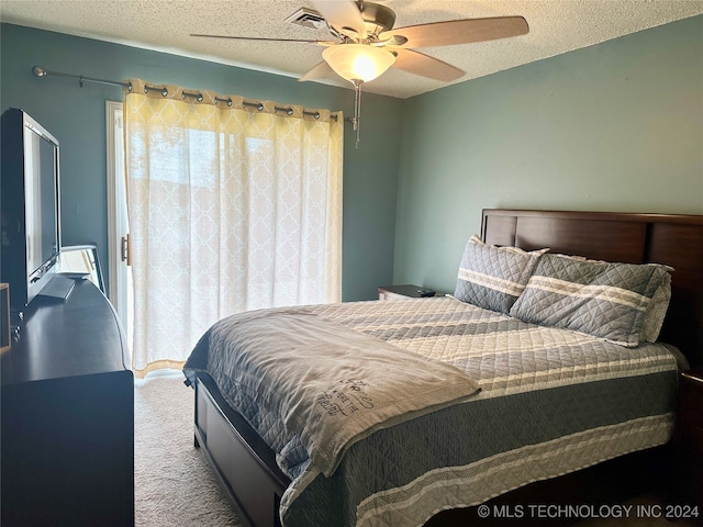 carpeted bedroom featuring a textured ceiling and ceiling fan