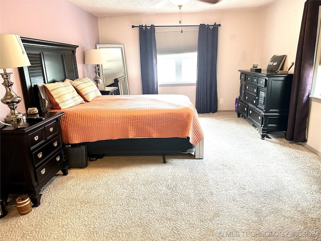 carpeted bedroom with a textured ceiling and ceiling fan