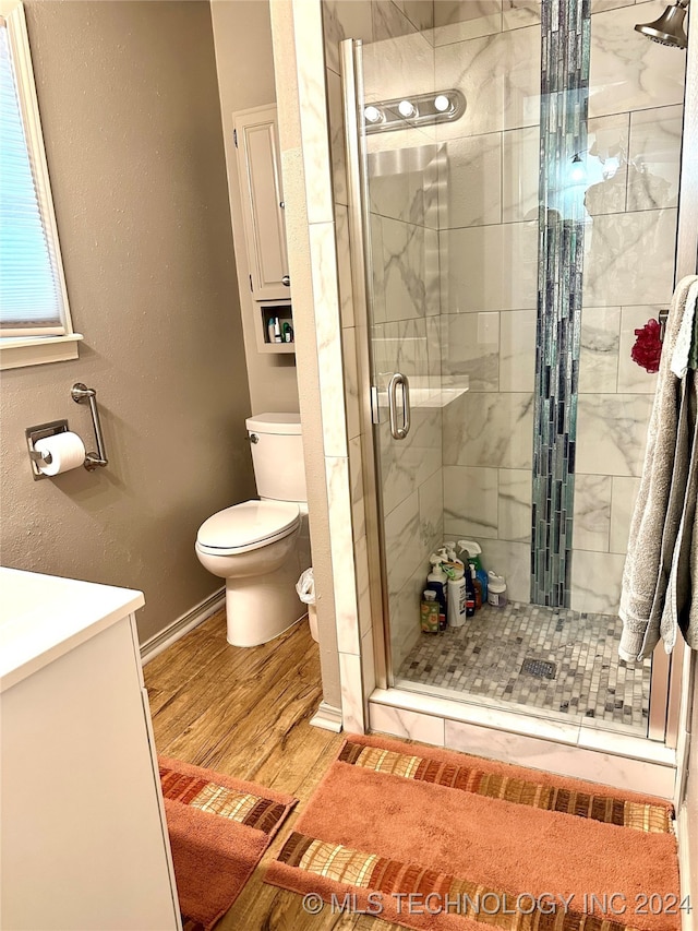 bathroom with toilet, an enclosed shower, vanity, and wood-type flooring