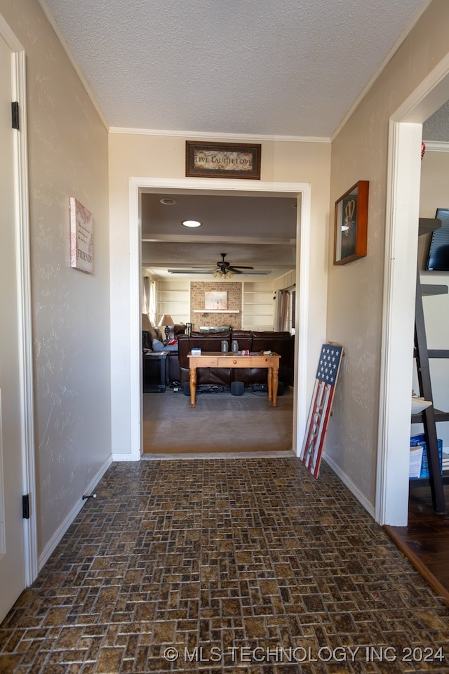 hallway with crown molding and a textured ceiling