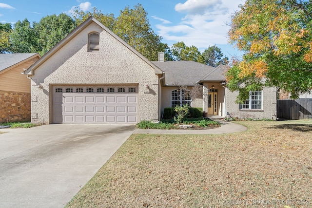 view of front of property featuring a front yard and a garage