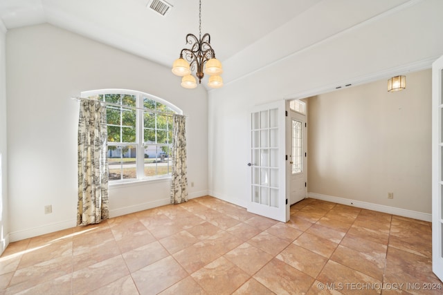 empty room featuring a chandelier and vaulted ceiling