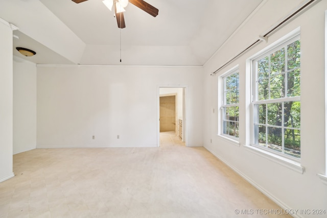 carpeted spare room with a raised ceiling and ceiling fan