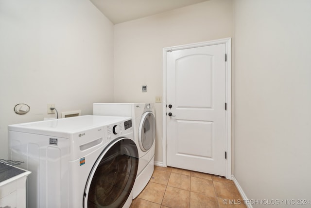 washroom with washing machine and clothes dryer and light tile patterned floors